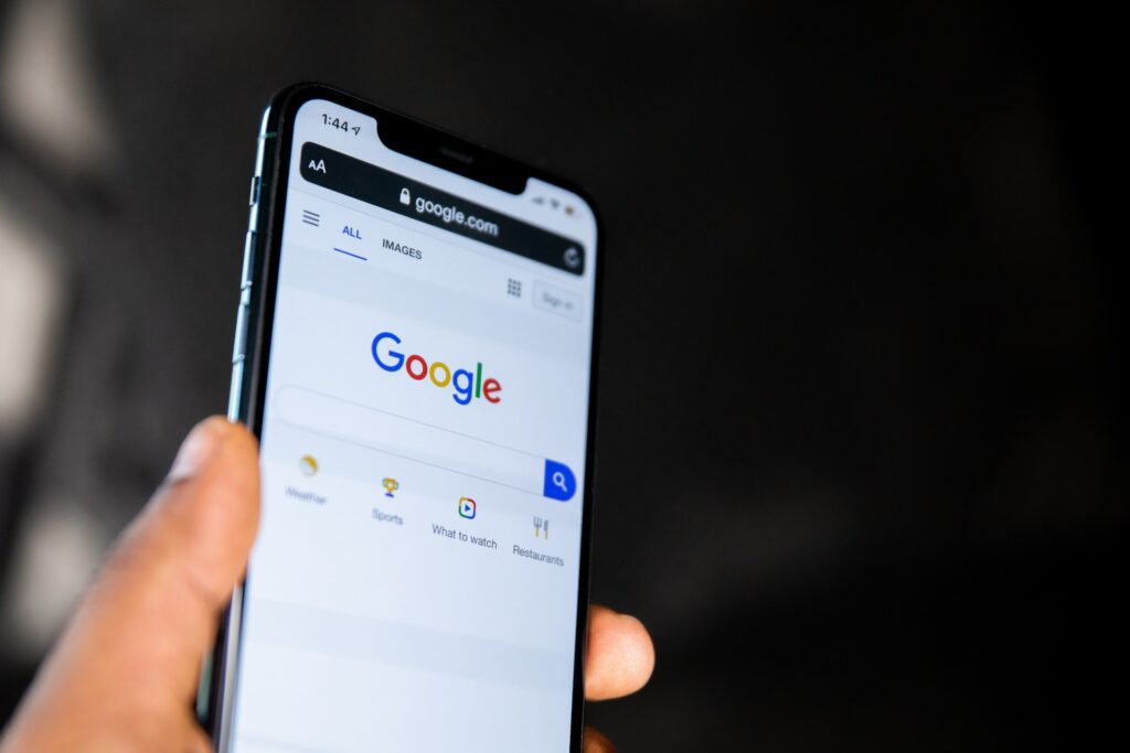 hand holding up phone with google search open