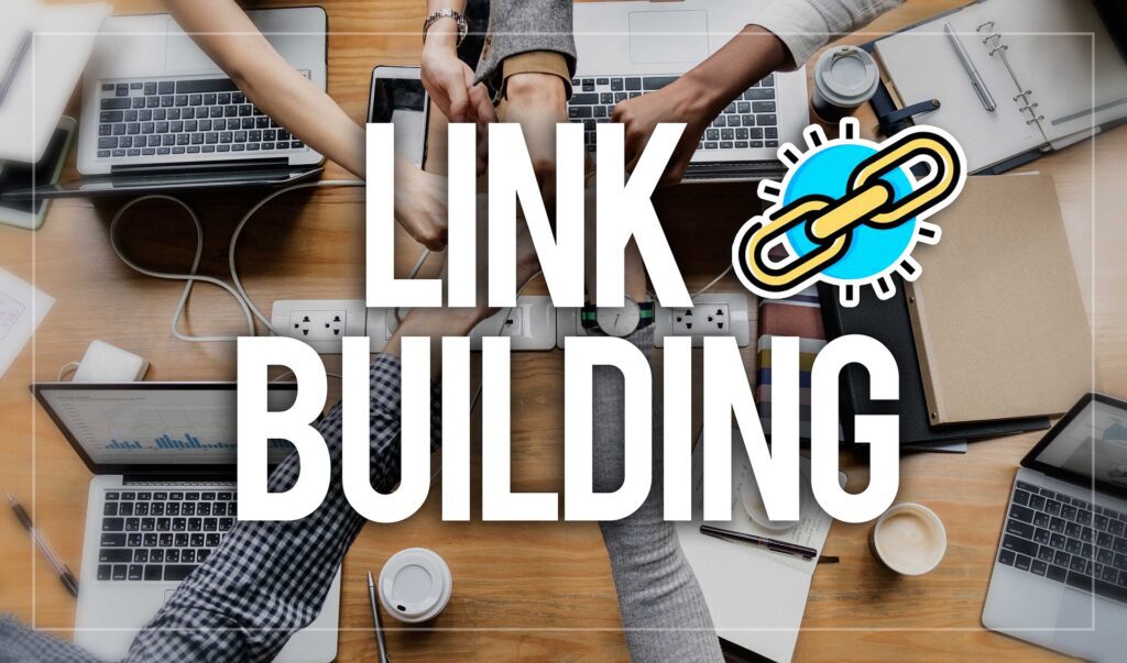 There are several laptops sitting on a table with people's hands coming together in the middle with a text overlay that says "Link Building."