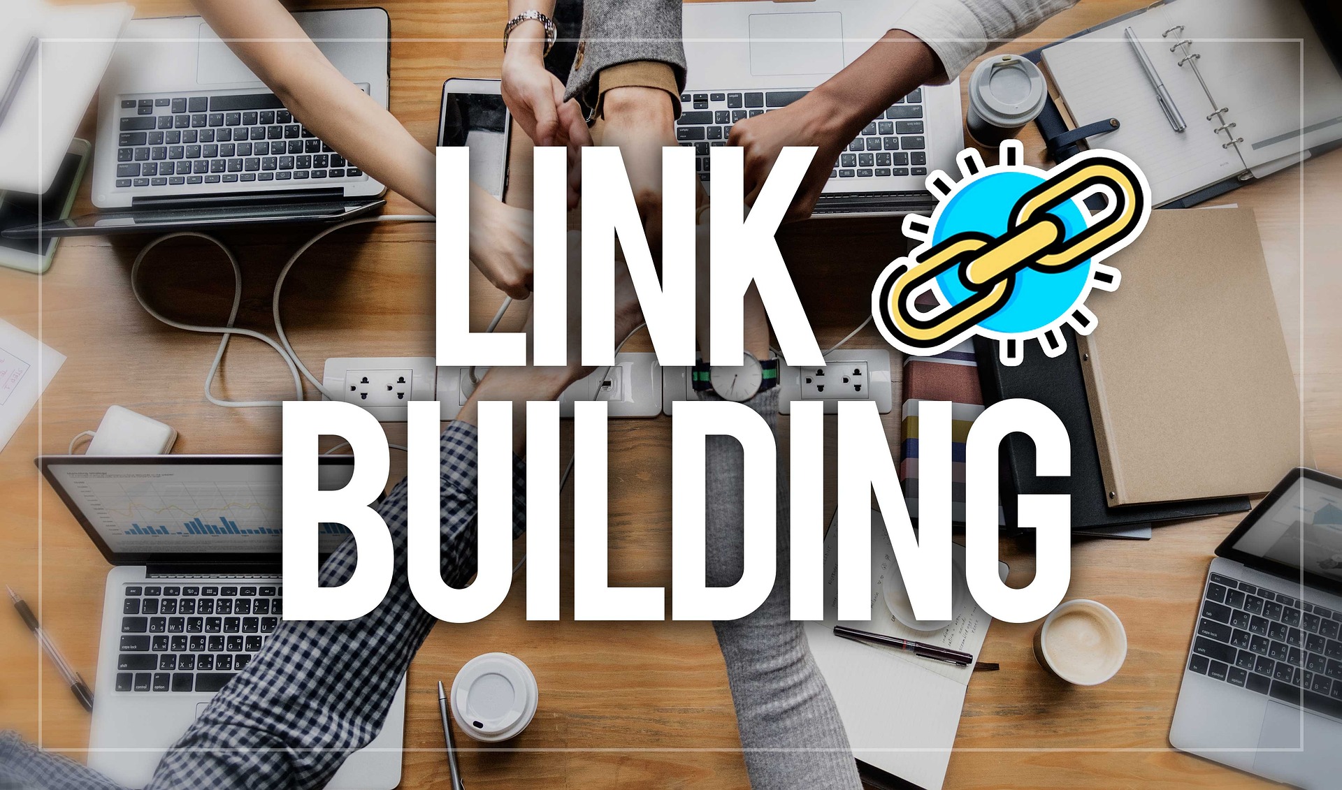 There are several laptops sitting on a table with people's hands coming together in the middle with a text overlay that says "Link Building."