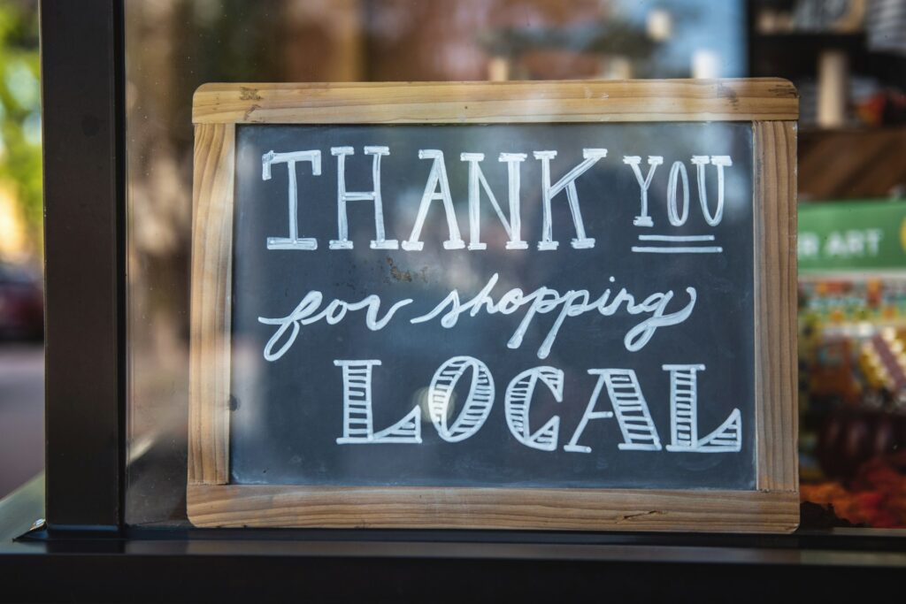 A sign in a shop window that says "Thank you for shopping local."