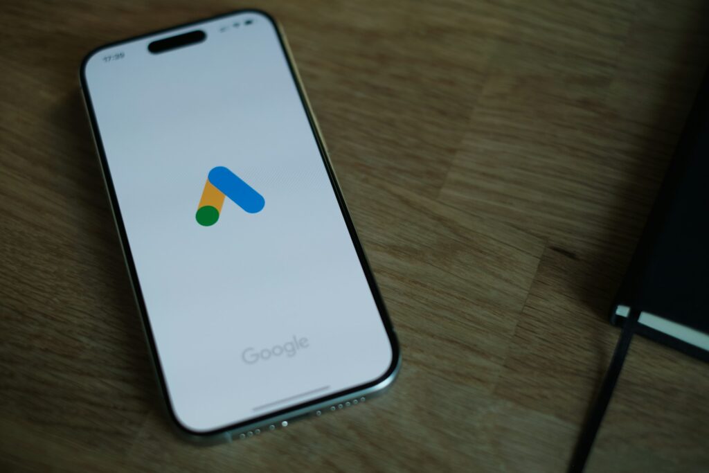 A cell phone is sitting on a table with Google Ads logo on screen.