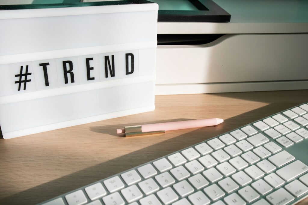 A plaque stating "#TREND" is sitting on a computer desk in front of a keyboard.