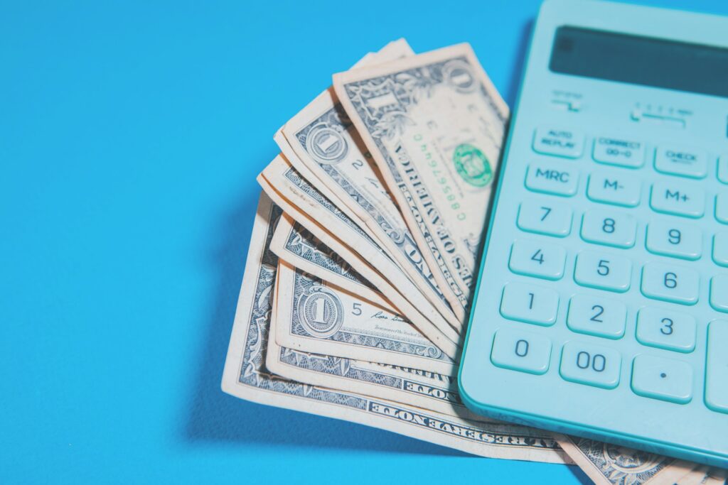 A calculator is sitting on top of a stack of money.