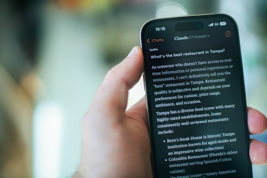 a person is holding a phone with claude open